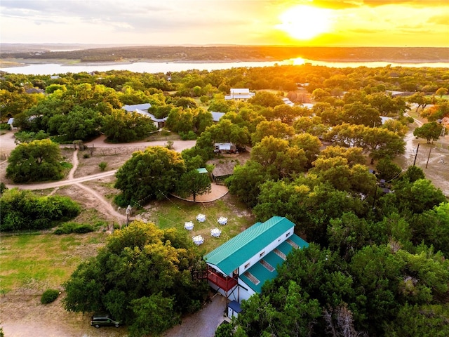 aerial view at dusk featuring a water view