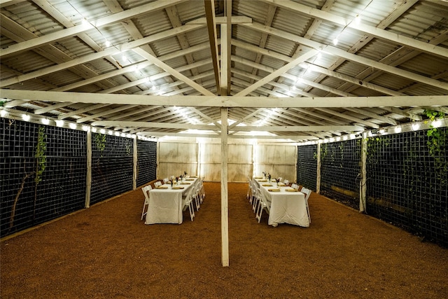 wine room featuring lofted ceiling with beams and dark carpet