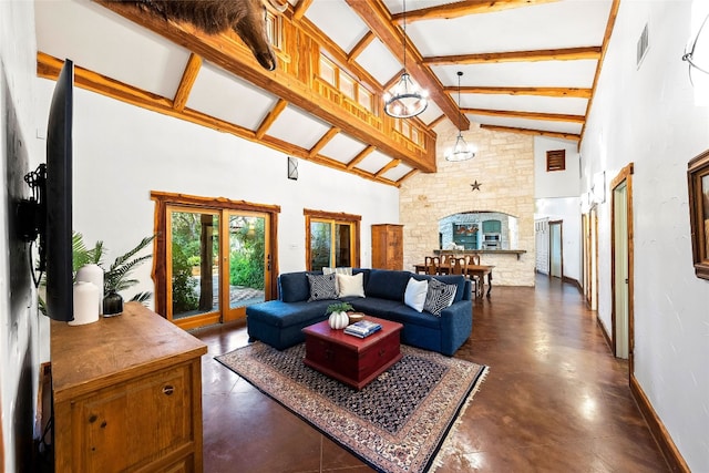 living room with a stone fireplace, beam ceiling, and high vaulted ceiling