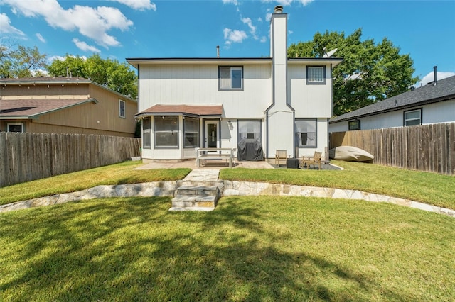 back of house featuring a lawn, a sunroom, and a patio area