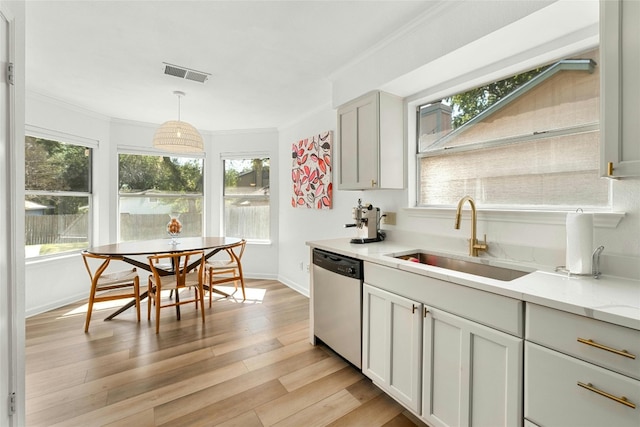 kitchen featuring light wood-type flooring, crown molding, sink, pendant lighting, and dishwasher