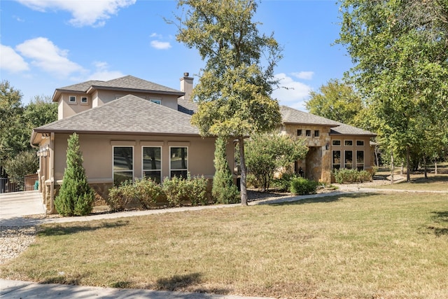 view of front of property featuring a chimney, a front lawn, and stucco siding