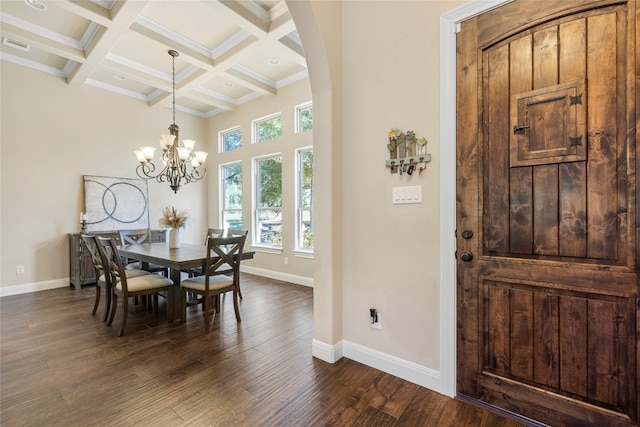 dining room with baseboards, coffered ceiling, dark wood finished floors, a towering ceiling, and beam ceiling