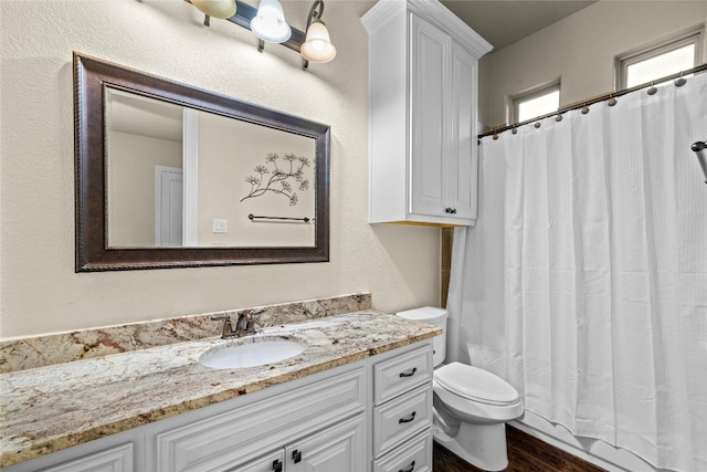 bathroom featuring hardwood / wood-style floors, toilet, vanity, and a shower with curtain