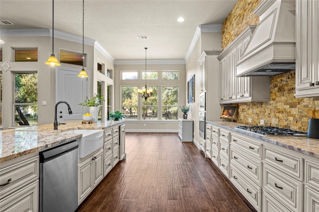 kitchen featuring premium range hood, hanging light fixtures, sink, appliances with stainless steel finishes, and dark hardwood / wood-style floors