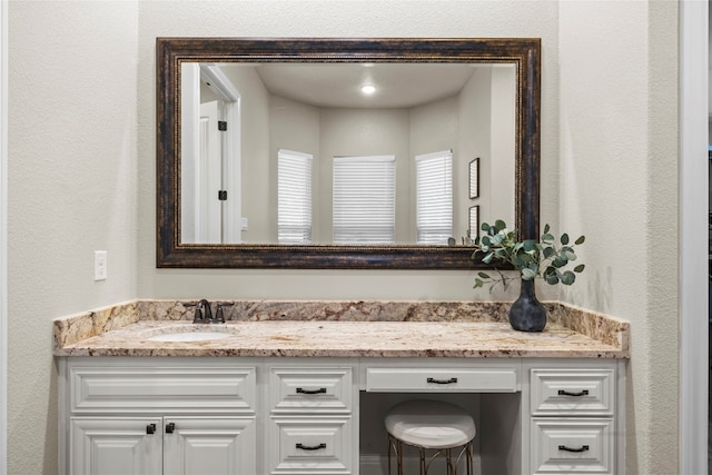 bathroom featuring a textured wall and vanity