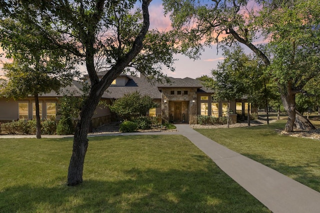 view of front of property with stone siding and a front lawn