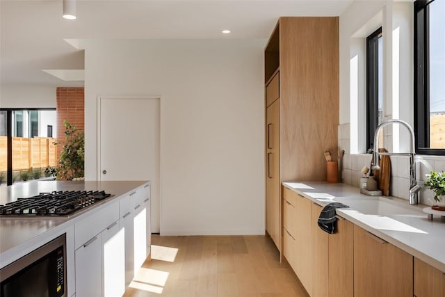 2112 Lawnmont Ave, Austin, TX 78756 - kitchen with appliances with stainless steel finishes, light countertops, recessed lighting, modern cabinets, and decorative backsplash