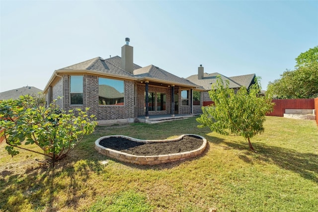 back of property featuring a patio and a yard