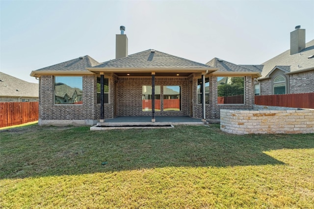 rear view of house with a lawn and a patio area