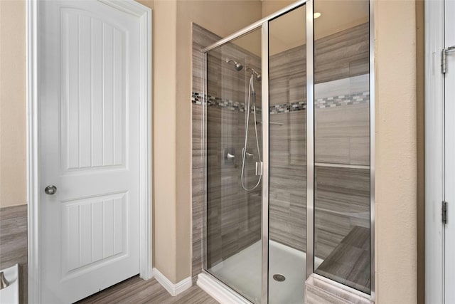 bathroom with walk in shower and hardwood / wood-style flooring