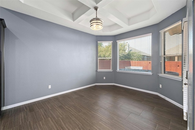 spare room featuring beamed ceiling, coffered ceiling, and dark hardwood / wood-style floors