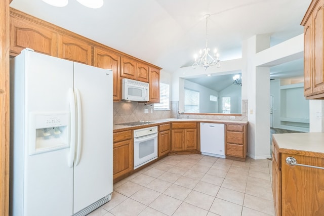 kitchen with lofted ceiling, white appliances, an inviting chandelier, decorative light fixtures, and backsplash