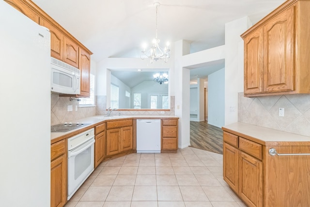 kitchen featuring tasteful backsplash, white appliances, pendant lighting, vaulted ceiling, and an inviting chandelier