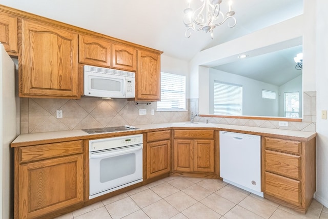 kitchen with lofted ceiling, light tile patterned floors, sink, white appliances, and a notable chandelier