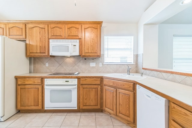 kitchen with white appliances, sink, light tile patterned floors, and tasteful backsplash