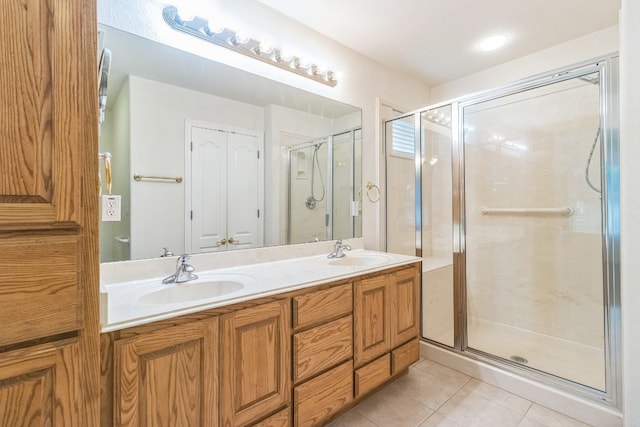 bathroom featuring vanity, a shower with shower door, and tile patterned floors