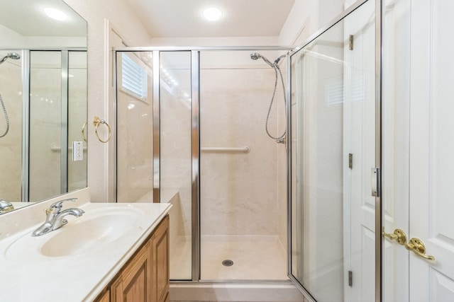 bathroom with a shower with door and vanity