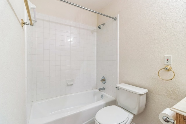 full bathroom featuring vanity, tiled shower / bath combo, and toilet