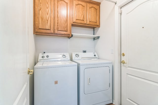 clothes washing area with cabinets and washing machine and dryer