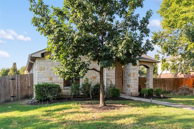 view of property hidden behind natural elements with a front lawn