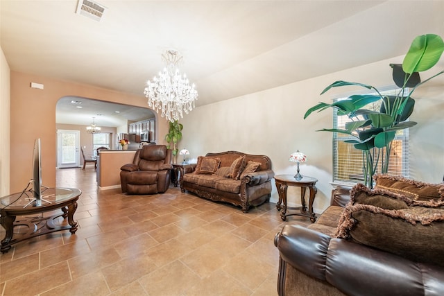 living room with an inviting chandelier, lofted ceiling, and light tile patterned floors