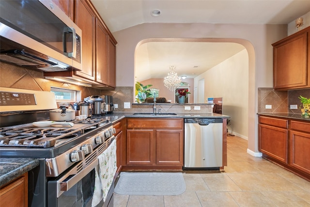 kitchen featuring lofted ceiling, a chandelier, sink, and stainless steel appliances