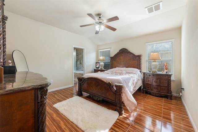 bedroom with ceiling fan, dark hardwood / wood-style floors, vaulted ceiling, and ensuite bath