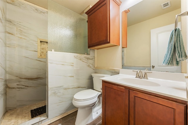 bathroom featuring walk in shower, toilet, tile patterned floors, tile walls, and vanity