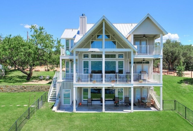 back of house featuring a patio, a balcony, ceiling fan, and a lawn