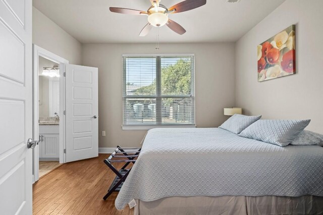 bedroom featuring ensuite bath, ceiling fan, and light wood-type flooring