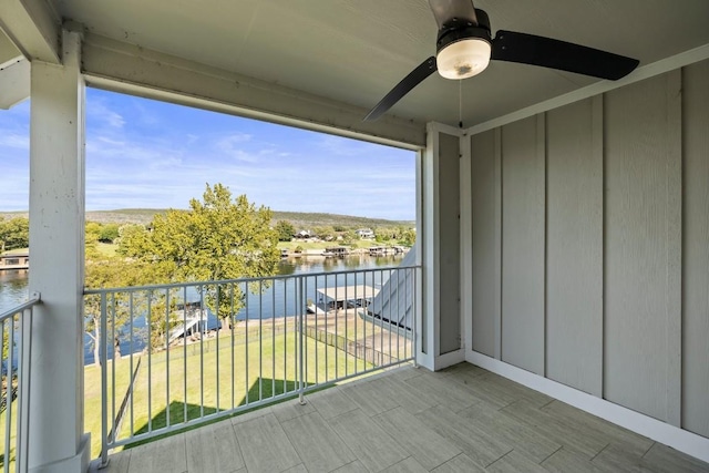 balcony with ceiling fan and a water view