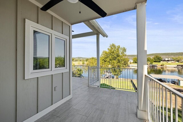 balcony featuring ceiling fan and a water view