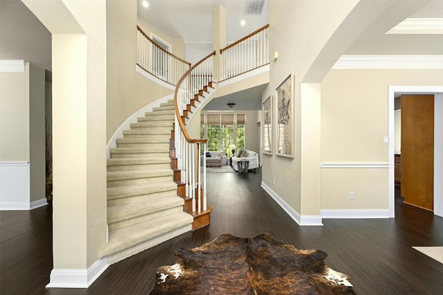 entryway with dark hardwood / wood-style floors and crown molding