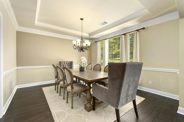 dining area with a raised ceiling, a chandelier, and dark hardwood / wood-style floors