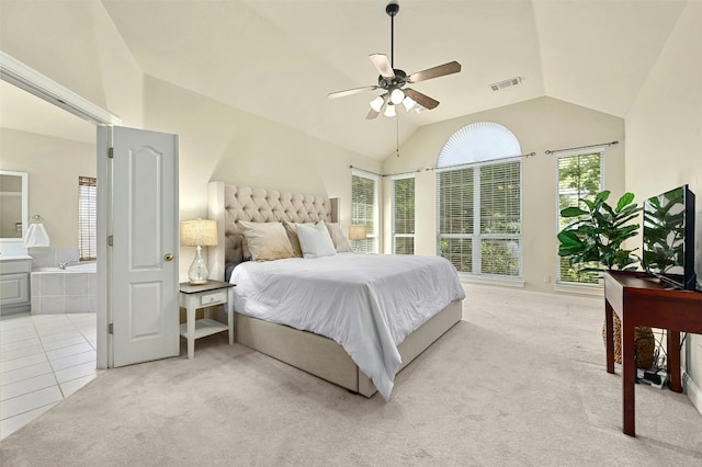 bedroom featuring ensuite bath, light colored carpet, vaulted ceiling, and ceiling fan