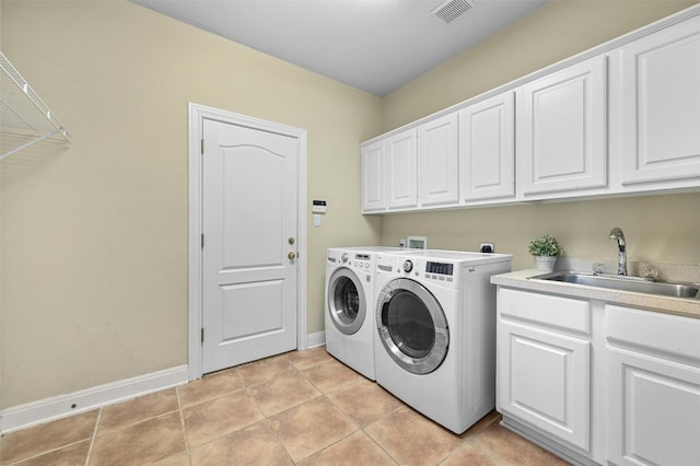 clothes washing area with washer and dryer, light tile patterned flooring, cabinets, and sink