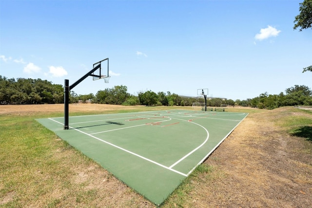 view of sport court featuring a lawn