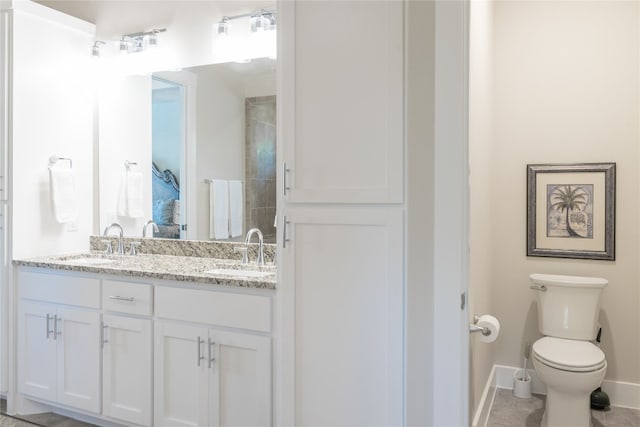 bathroom with toilet, tile patterned flooring, and vanity