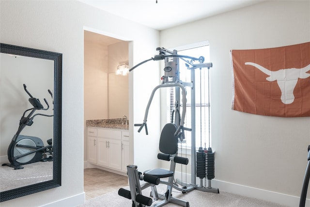 exercise area with light tile patterned flooring and sink