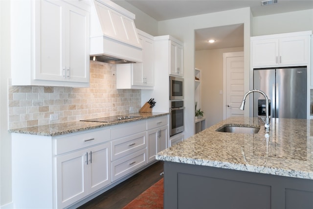 kitchen featuring stainless steel fridge, sink, white cabinetry, and black electric stovetop