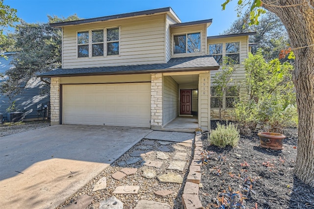 view of front of property featuring concrete driveway, stone siding, roof with shingles, and an attached garage