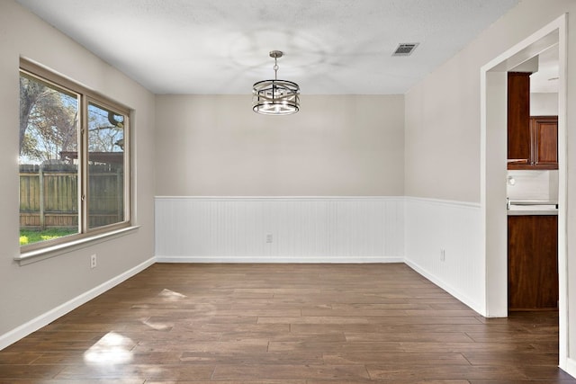 4910 Pelham Dr, Austin, TX 78727 - unfurnished dining area with a wainscoted wall, a chandelier, and wood-type flooring