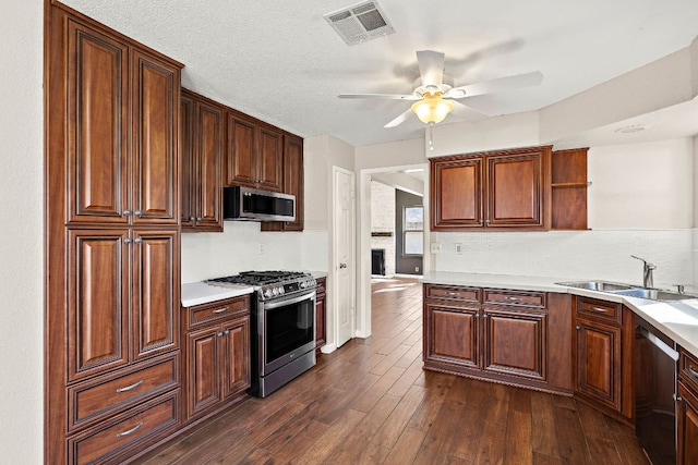 4910 Pelham Dr, Austin, TX 78727 - kitchen with stainless steel appliances, open shelves, ceiling fan, backsplash, and dark wood-style floors