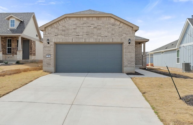 view of front of home featuring driveway, roof with shingles, a garage, central air condition unit, and brick siding