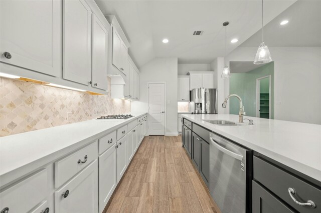 kitchen featuring appliances with stainless steel finishes, decorative light fixtures, sink, and white cabinets