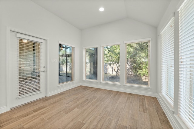 unfurnished sunroom featuring lofted ceiling and plenty of natural light