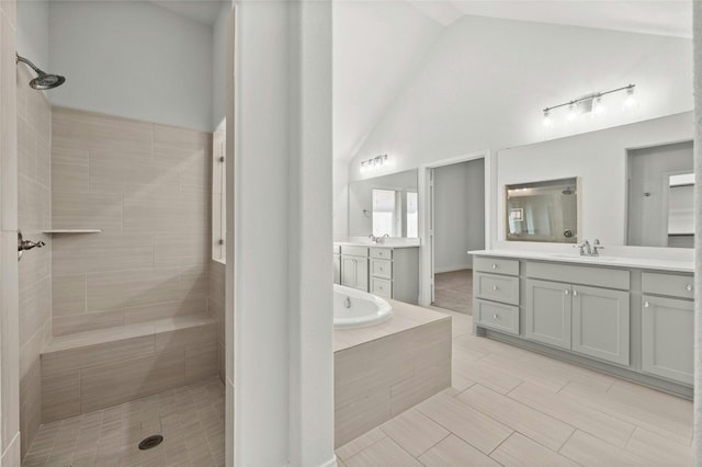 bathroom with independent shower and bath, vanity, and high vaulted ceiling