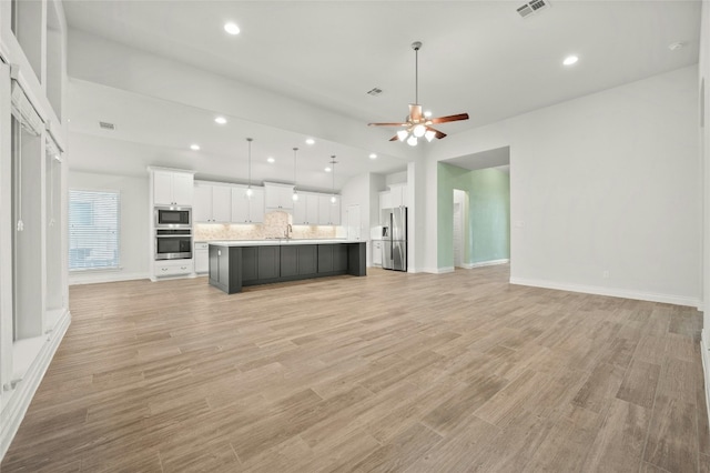 unfurnished living room featuring ceiling fan, light hardwood / wood-style flooring, and sink