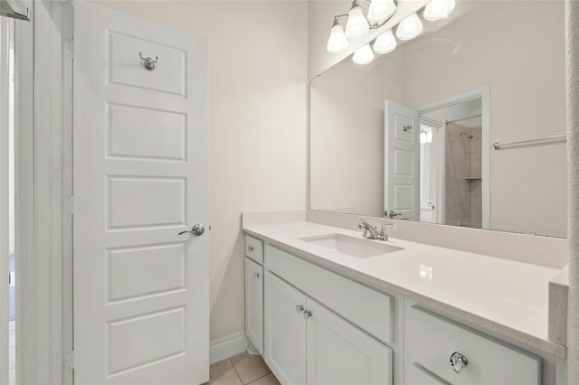 bathroom featuring a tile shower, vanity, and tile patterned flooring